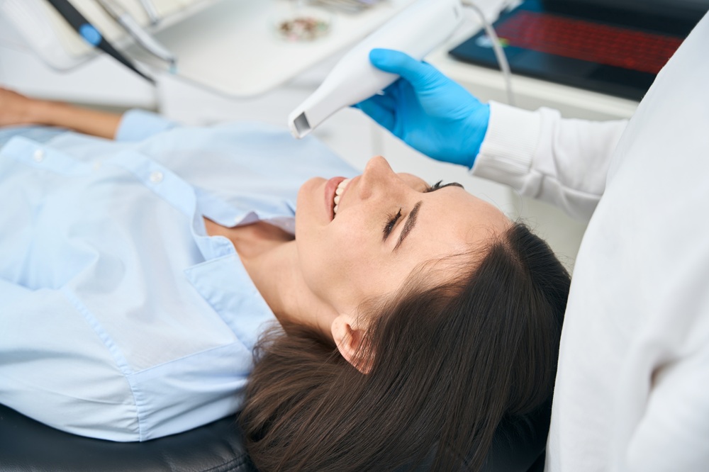 A patient smiles comfortably as a dentist uses an intraoral camera to capture detailed images of the teeth and gums for accurate diagnosis. – Intraoral Camera