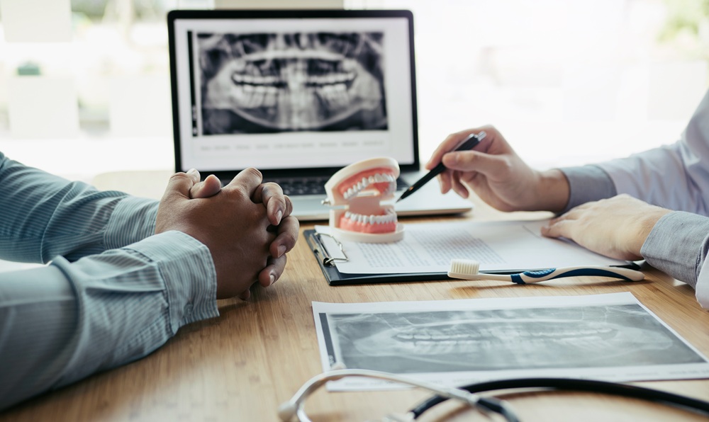 Dental Consultation with X-Ray Analysis – Digital X-Ray A dentist discusses a patient’s dental X-rays and oral health plan during a consultation, highlighting the precision of modern digital radiography. – Digital X-Ray