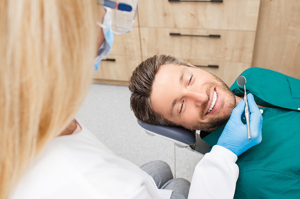 Relaxed Patient During Routine Cleaning – Dental Cleaning in Seattle A smiling patient enjoys a comfortable dental cleaning as the hygienist gently polishes his teeth for a fresh and confident smile. – Dental Cleaning in Seattle