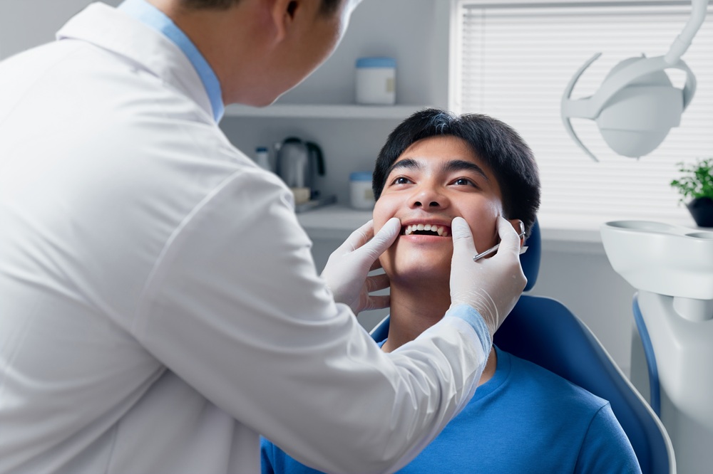 Dentist Examining Patient’s Teeth – General Dentistry A dentist carefully examines a patient’s teeth during a routine check-up, ensuring early detection and prevention of dental issues. – General Dentistry