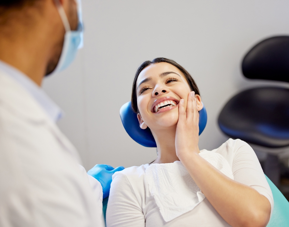 A smiling woman relaxes in the dental chair after a stress-free procedure made possible by gentle sedation, ensuring a calm and positive experience. – Sedation Dentistry