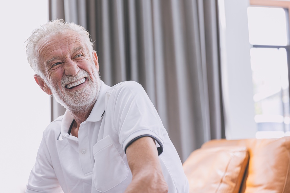 A happy senior man with a confident smile enjoys the comfort and natural appearance of his new, custom-fitted dentures. – Dentures in Seattle